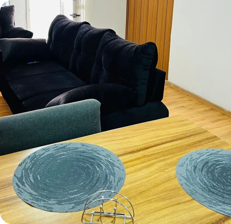 Imagen donde se ve una comedor con un mueble negro y una mesa con una silla