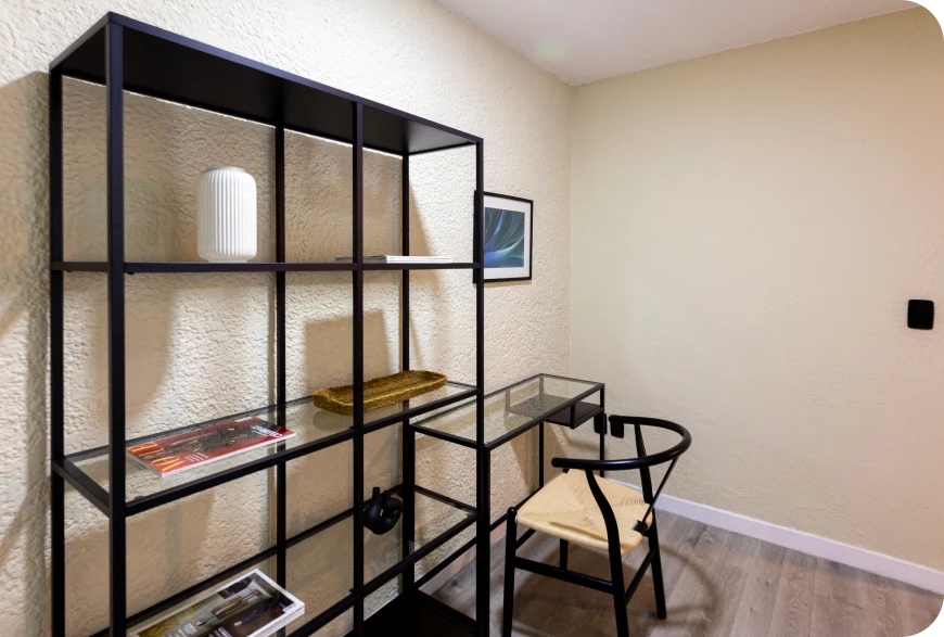 Imagen donde se muestra un cuarto que contiene una silla y un estante de 3 niveles